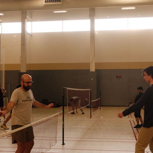 Members playing pickleball in a campus gym